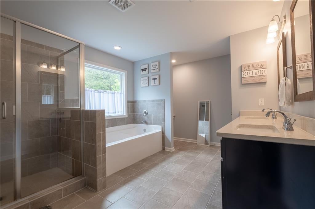 719 Fairview Road Brooks, GA 30205 - Photo 5 of 35 a bathroom with a bathtub a shower a sink and a window