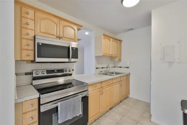 a kitchen with stainless steel appliances granite countertop a stove microwave and cabinets