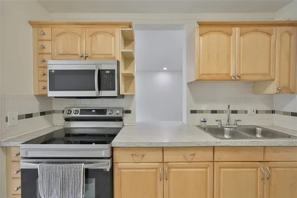 a kitchen with appliances a sink and cabinets