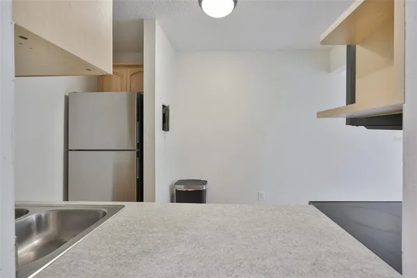 a view of a kitchen with a sink and refrigerator