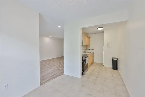 a view of a kitchen with refrigerator and white cabinets