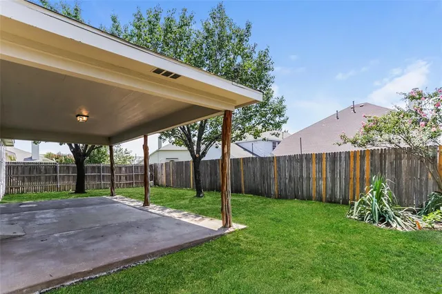 a view of a backyard with plants and wooden fence