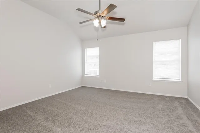 an empty room with a window and a fan