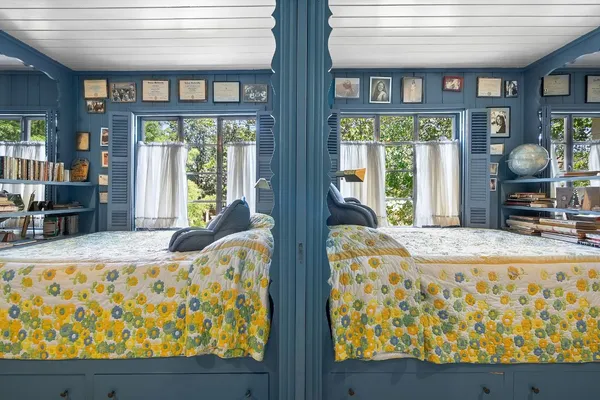 a bedroom with furniture and large windows