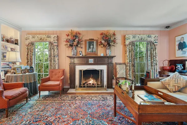 a living room with furniture a large window and a fireplace
