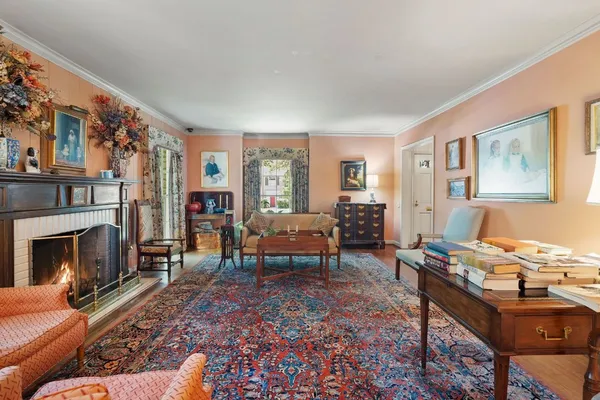 a living room with furniture a fireplace and next to a window
