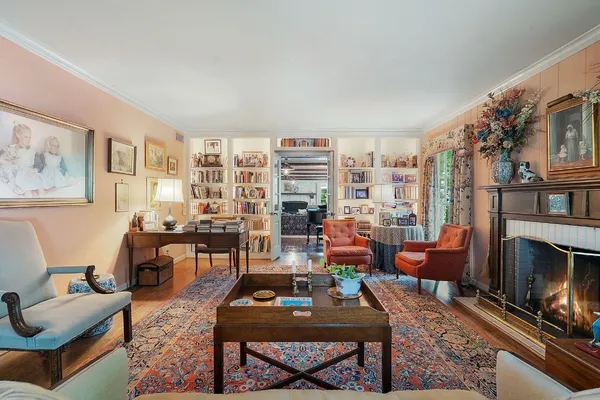 a living room with furniture a fireplace and a large window