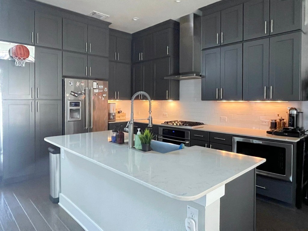 7511 Wildcat Pass Austin, TX 78757 - Photo 7 of 24 a kitchen with stainless steel appliances a sink a refrigerator and wooden cabinets