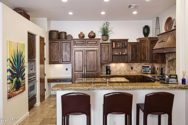a kitchen with stainless steel appliances granite countertop a stove a refrigerator and a refrigerator