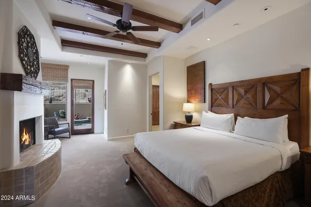 a view of a livingroom with a fireplace a ceiling fan and windows