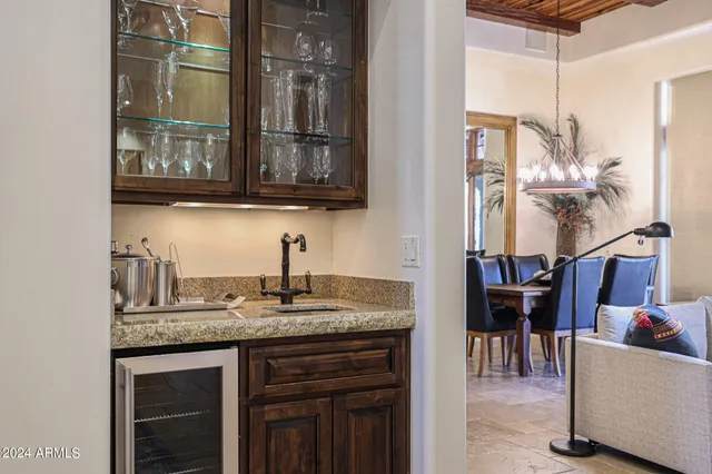 a kitchen with kitchen island granite countertop a sink and a refrigerator
