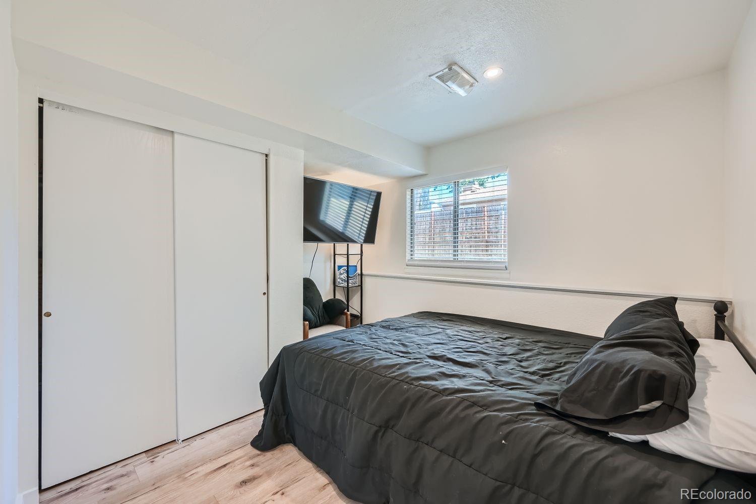 4600 Dillon Street Denver, CO 80239 - Photo 19 of 27 a bedroom with a bed and flat screen tv