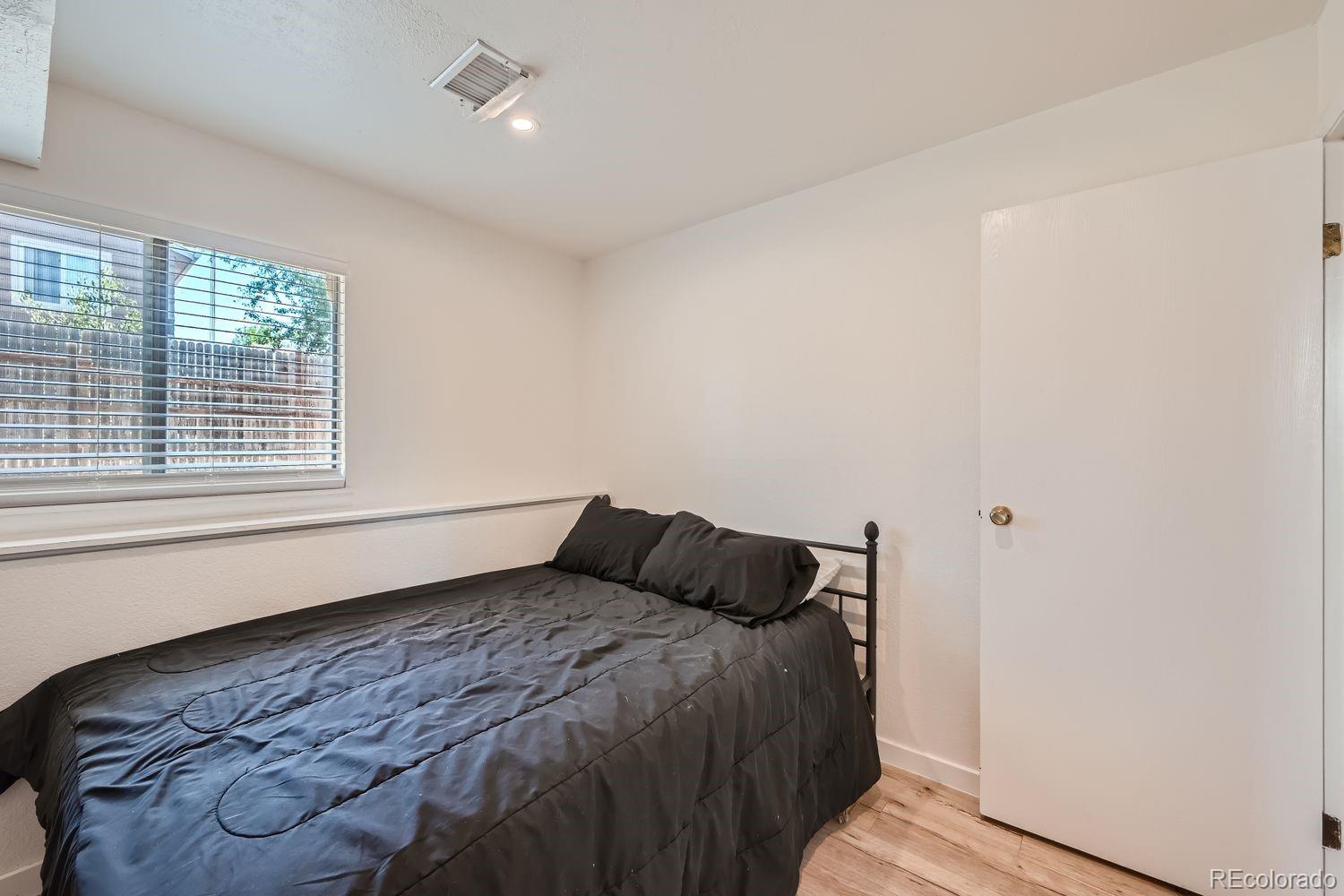 4600 Dillon Street Denver, CO 80239 - Photo 21 of 27 a bedroom with a bed and window