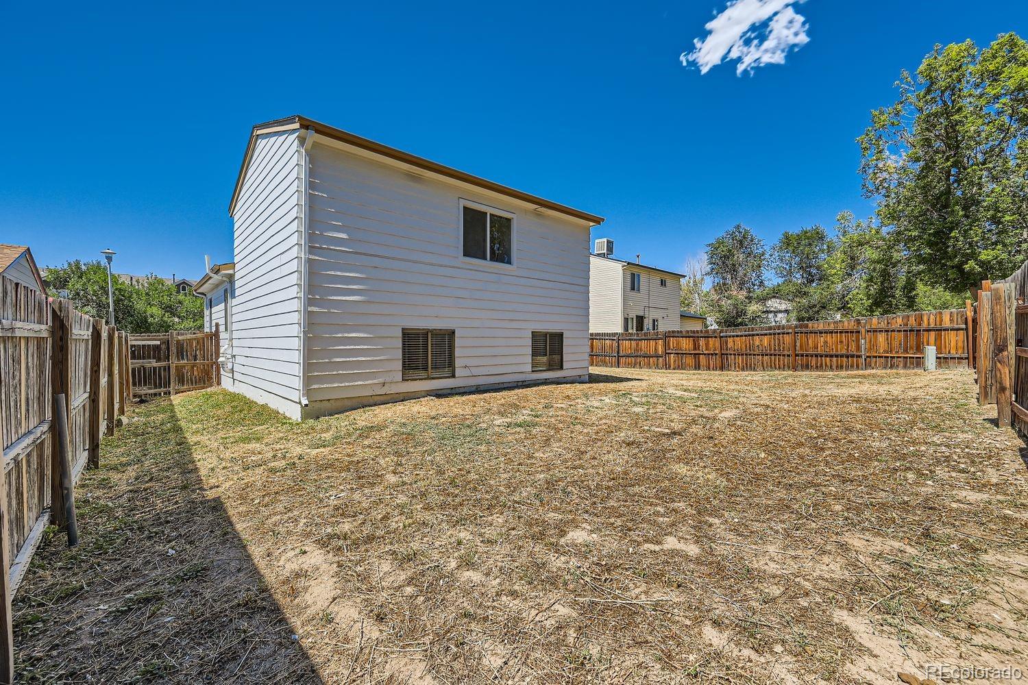4600 Dillon Street Denver, CO 80239 - Photo 24 of 27 a backyard of a house with large trees