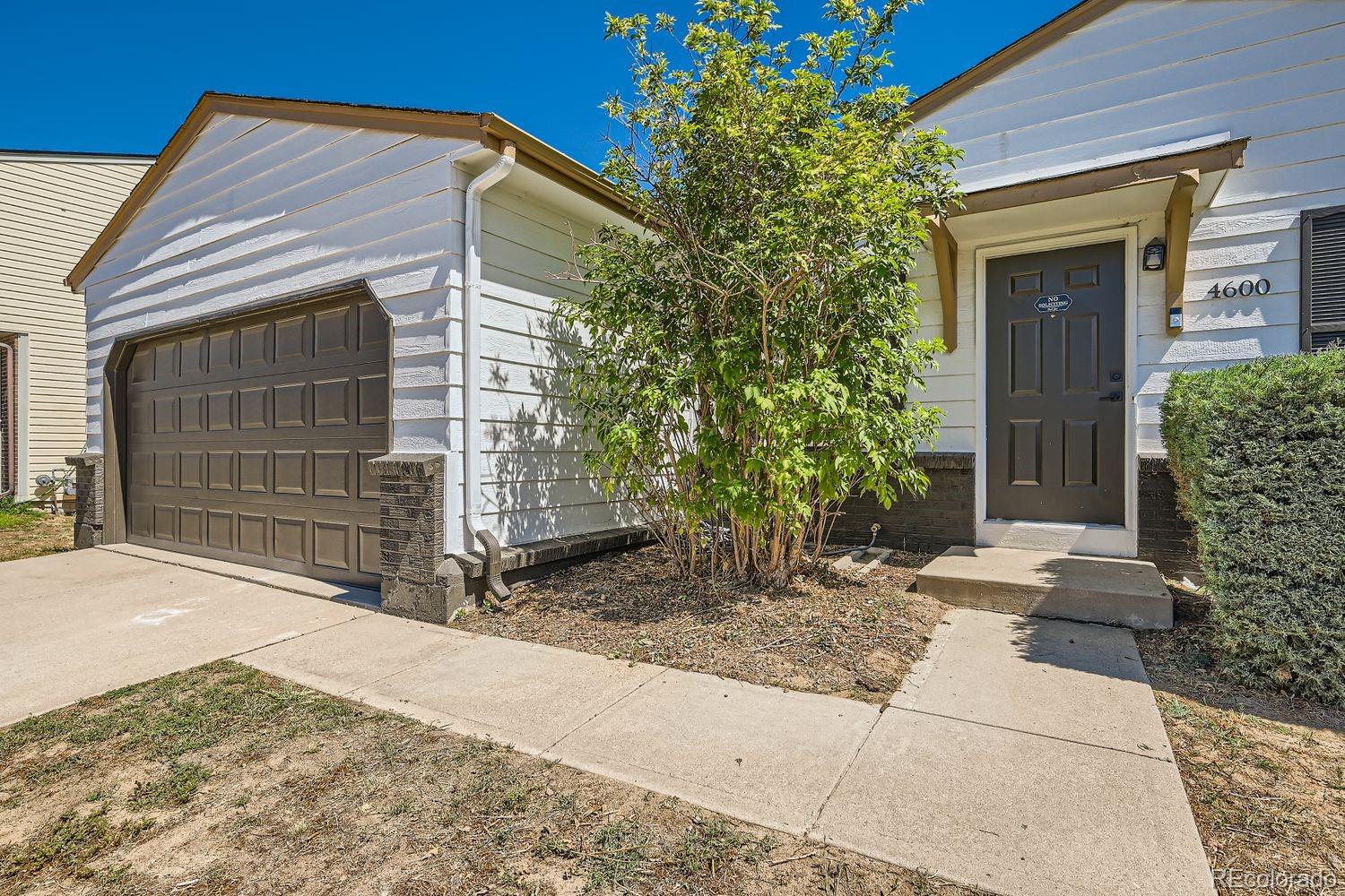 4600 Dillon Street Denver, CO 80239 - Photo 26 of 27 a front view of a house with garden