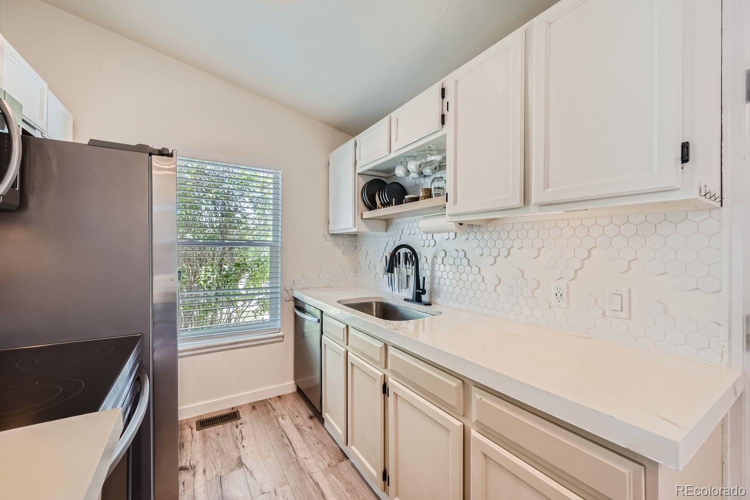 4600 Dillon Street Denver, CO 80239 - Photo 6 of 27 a kitchen with a sink and a stove top oven