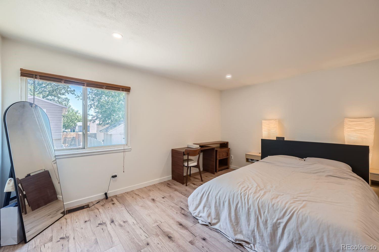 4600 Dillon Street Denver, CO 80239 - Photo 9 of 27 a bedroom with a bed and wooden floor