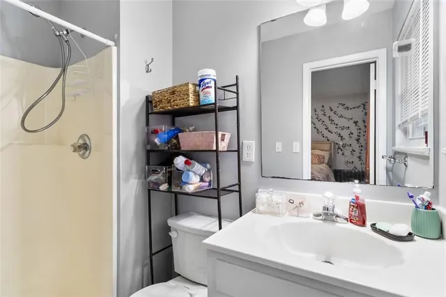 a bathroom with a sink a toilet and shower