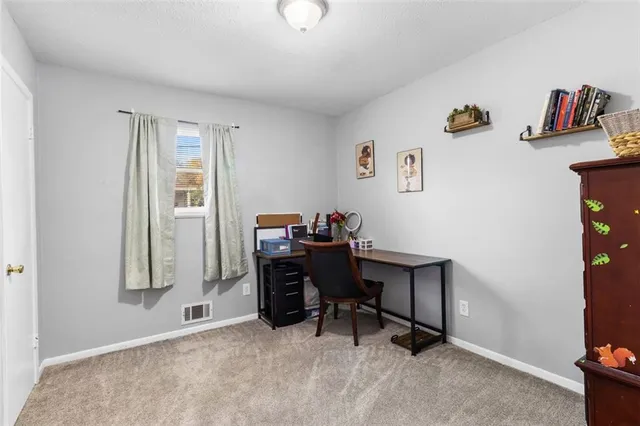 a view of a workspace with furniture and a window