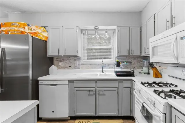 a kitchen with cabinets appliances a sink and a window