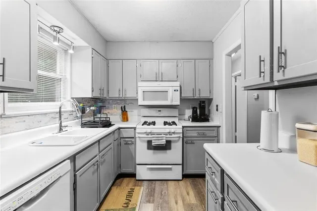 a kitchen with a sink a stove and cabinets