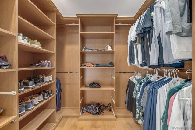 a view of walk in closet with clothes and shoes