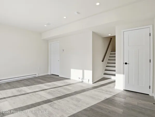 an empty room with wooden floor and stairs