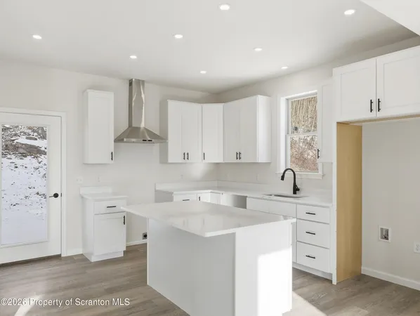 a kitchen with white cabinets and refrigerator