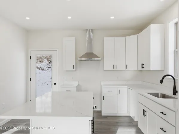 a kitchen with stainless steel appliances white cabinets and a refrigerator