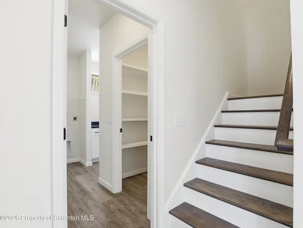 a view of entryway with wooden floor and white walls