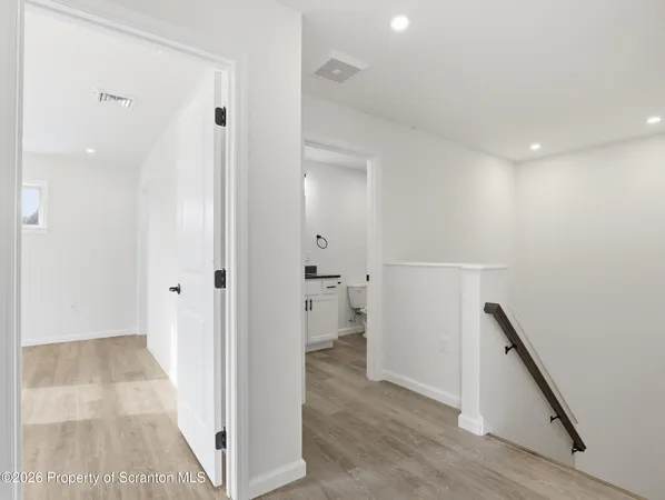 a view of a hallway with wooden floor and staircase