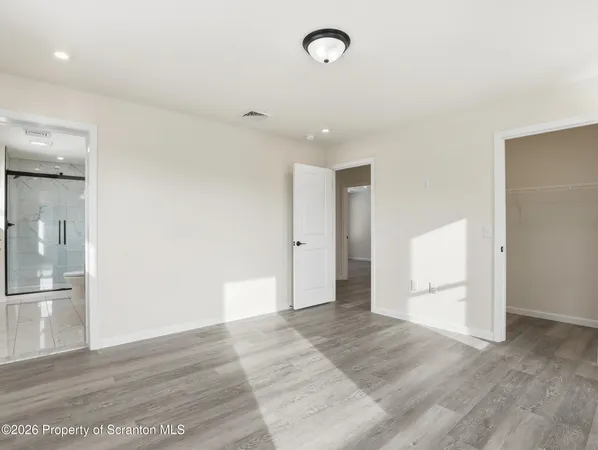 a view of empty room with wooden floor