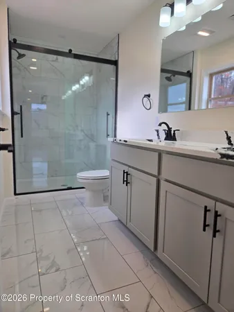 a bathroom with a double vanity sink toilet and shower