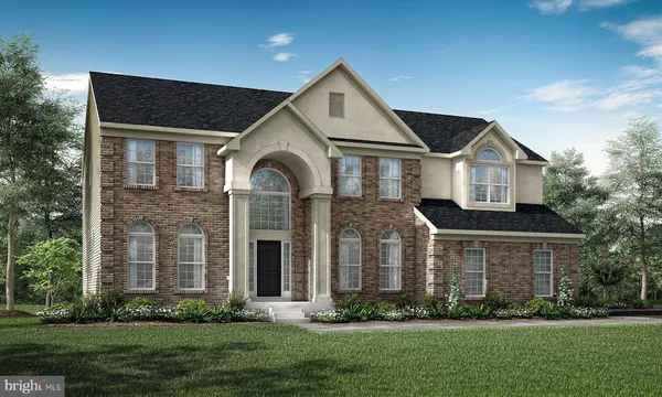 a front view of a house with a yard and green space