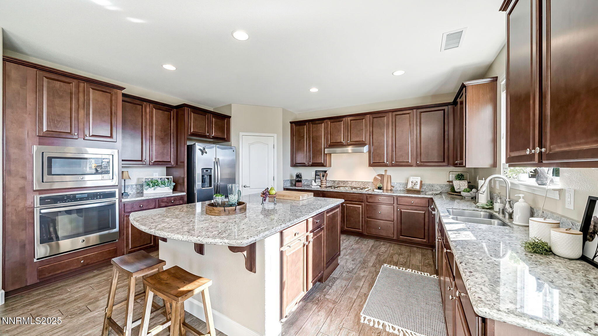 10115 Barrel Racer Drive Reno, NV 89521 - Photo 10 of 74 a kitchen with kitchen island granite countertop wooden cabinets a sink dishwasher a stove and a refrigerator with wooden floor