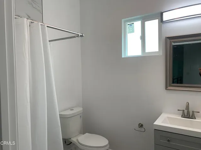 a bathroom with a toilet a sink and a mirror