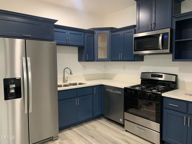 a kitchen with stainless steel appliances granite countertop a refrigerator stove a sink dishwasher and microwave oven