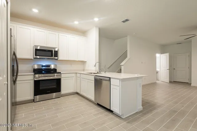 a kitchen with stainless steel appliances kitchen island granite countertop a stove a sink and a refrigerator