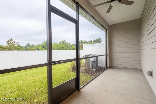 a view of a livingroom with a ceiling fan & windows