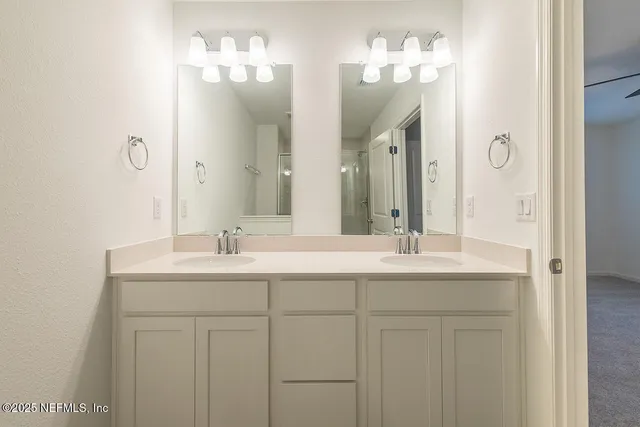 a bathroom with double vanity sinks and a mirror