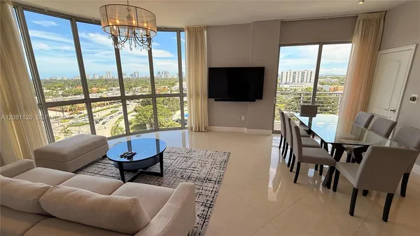 a living room with furniture a flat screen tv and a large window