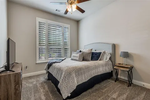 a bedroom with a bed a lamp and a large window