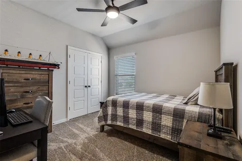 a bedroom with a bed and a lamp on the dresser