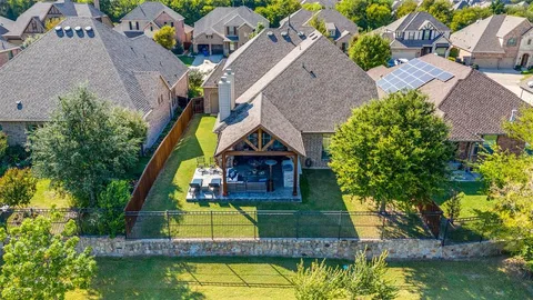 an aerial view of a house with swimming pool and a yard