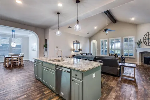 a kitchen with a sink stove and wooden floor
