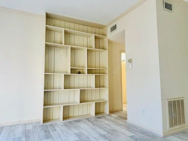 a view of a room with wooden floor and shelves