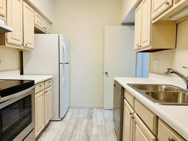 a kitchen with stainless steel appliances granite countertop a sink stove and refrigerator