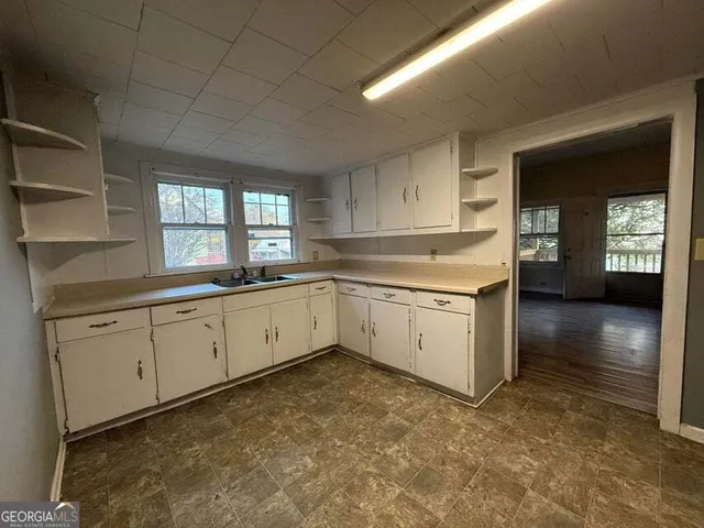 a kitchen with granite countertop white cabinets and white appliances