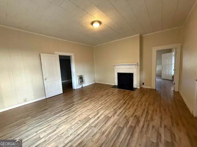 a view of empty room with wooden floor and fireplace