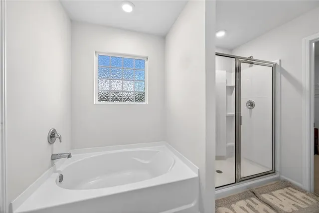 a white bath tub sitting next to a shower